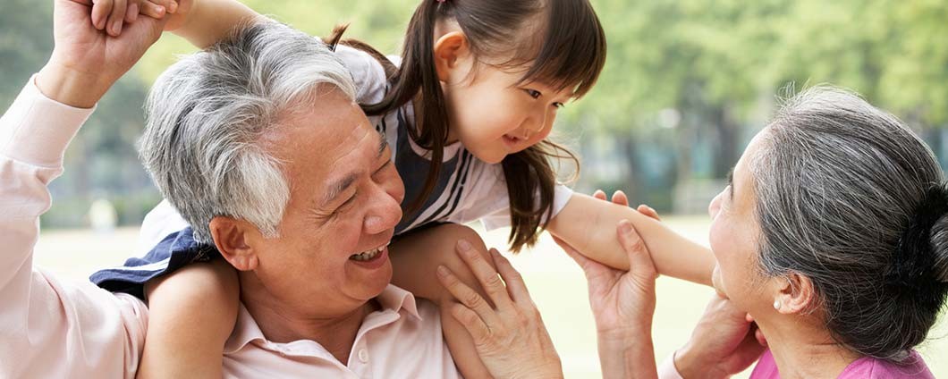 grandchild on grandfather's shoulders, holding grandmother's hand