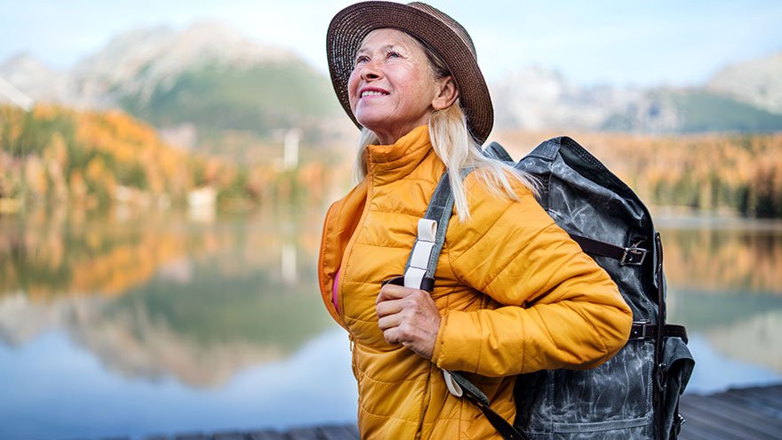 A senior woman standing by the lake