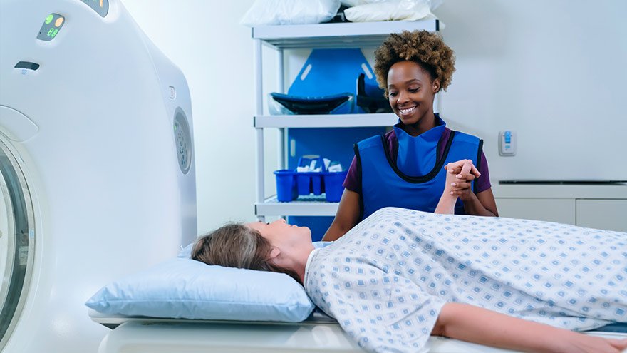 Technician holding hand of patient at scanner