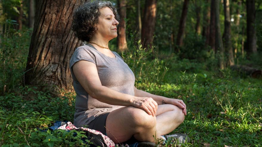 A woman meditating outdoors