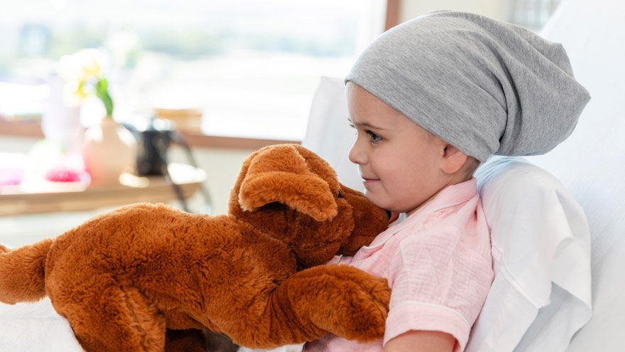 Little girl cancer patient holding stuffed dog