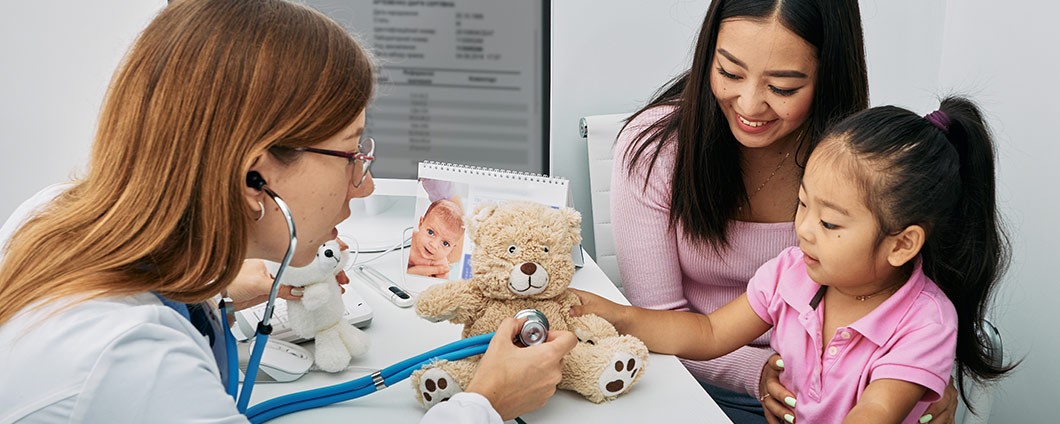 Research provider working with child patient as her mom looks on