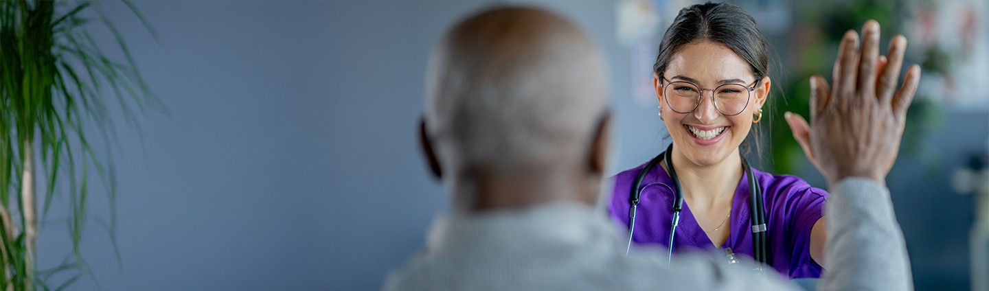 A provider smiling while she high-fives her clinical trials patient