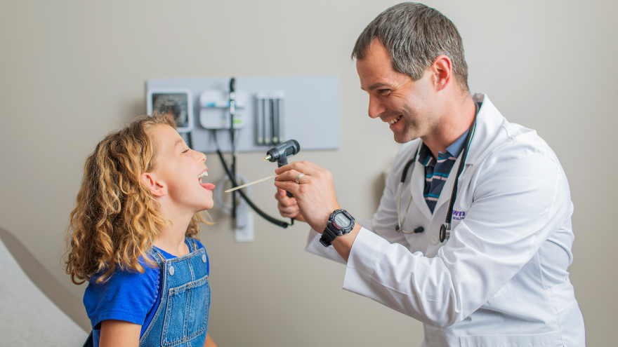 A doctor examines a child in a medical office.