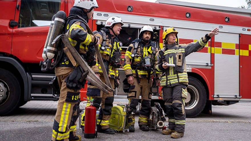 Firefighters team in front of fire engine