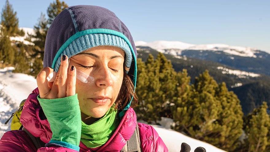 Woman applying sunscreen outside