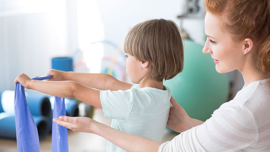 Care giver accessing young patient regarding scoliosis
