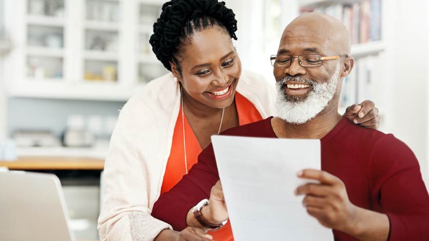 A couple smiling at a piece of paper