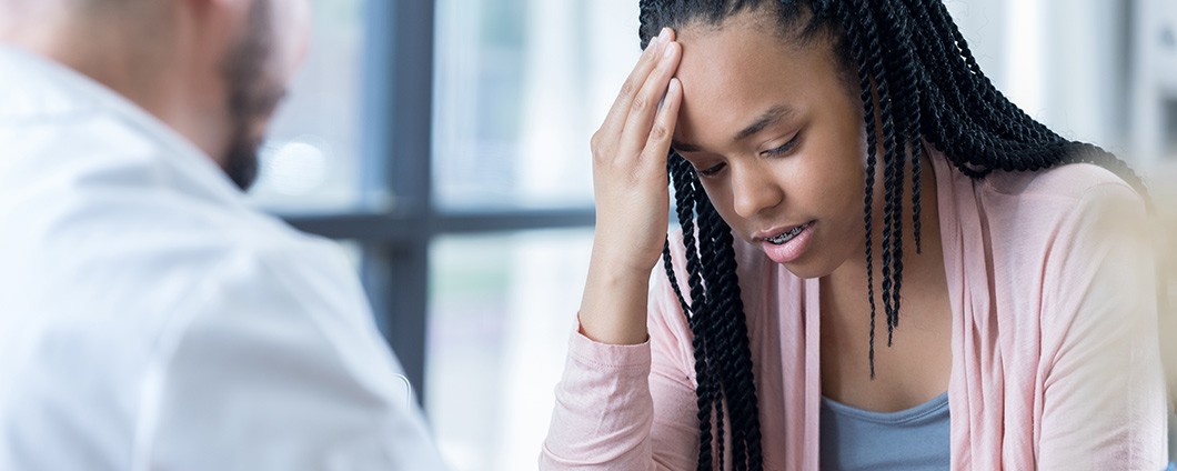 Hopeful teenage girl listens to physician's migraine treatment plan