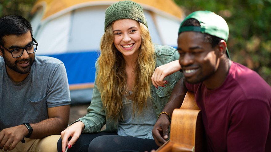 Group of people at campground, man playing guitar