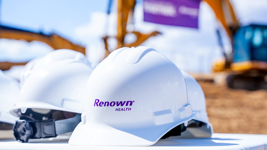Hard hats in foreground during ground breaking event in Sparks, NV