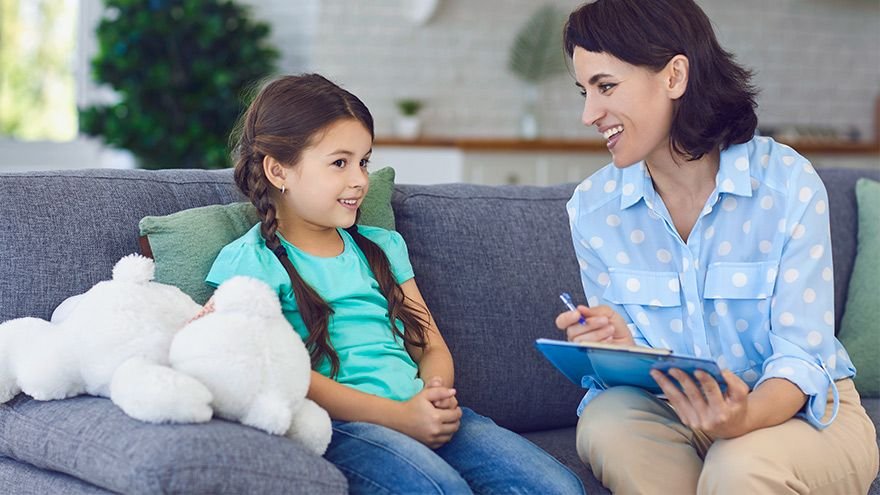 Child and therapist sitting on couch in conversation