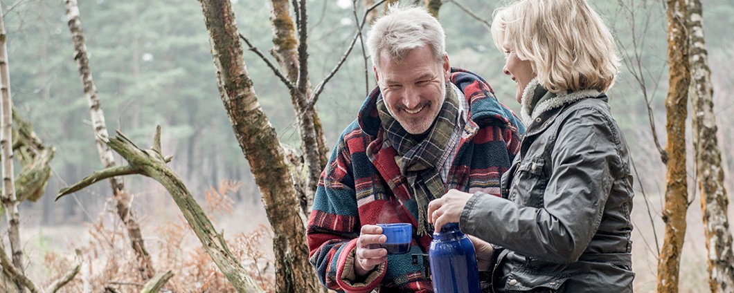 Senior couple enjoying a break during a woodland walk