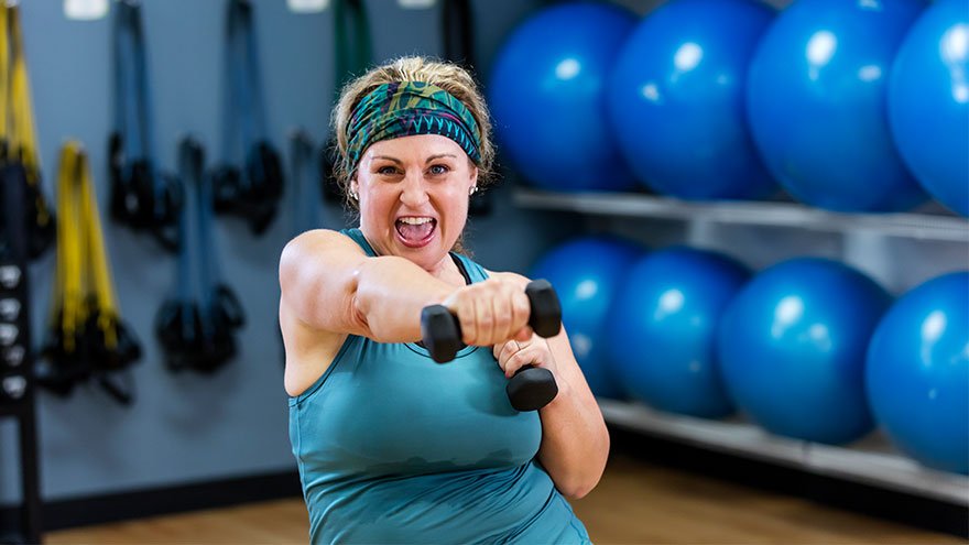 Mature Hispanic woman exercising with hand weights
