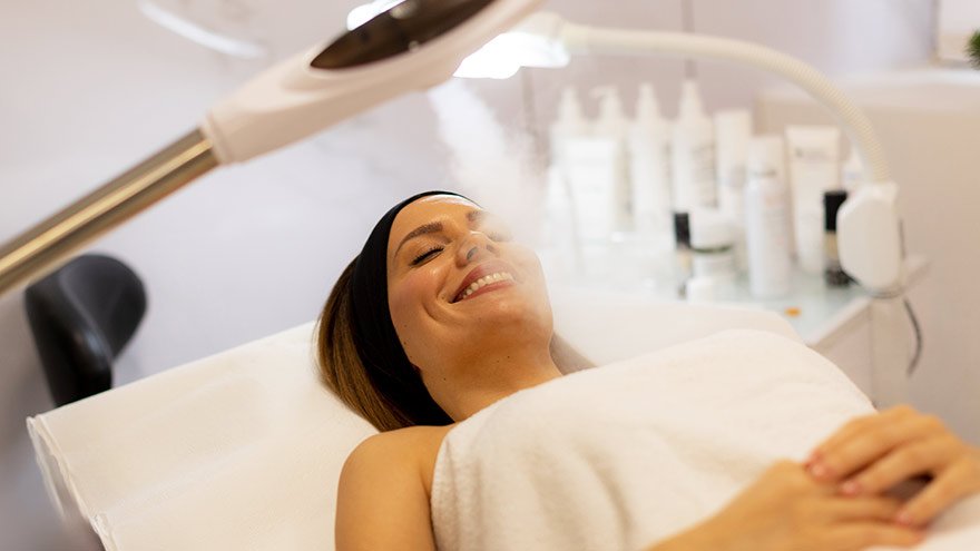 Woman enjoying steam Omnilux facial