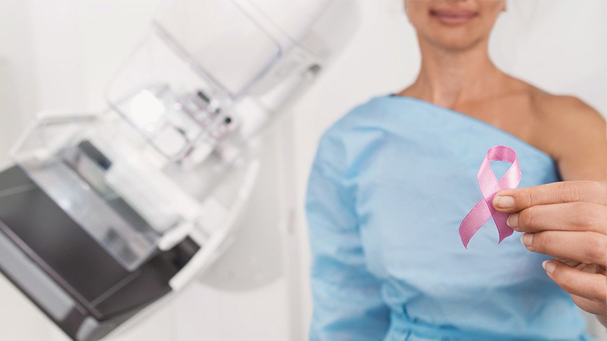 Woman undergoing mammogram shows pink ribbon
