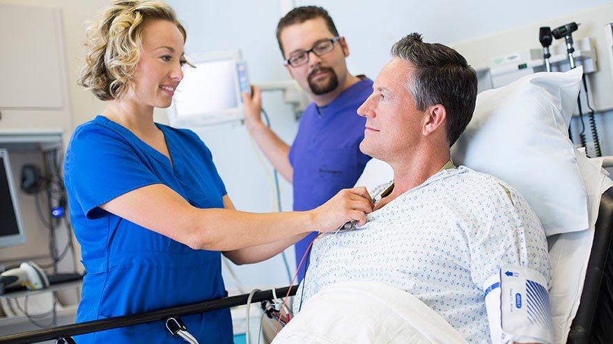 Two Nurses treating a patient in bed