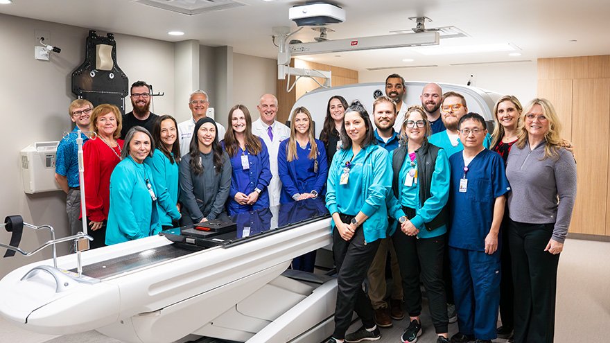 Radiation oncology team near new RT revolution scanner for cancer treatment
