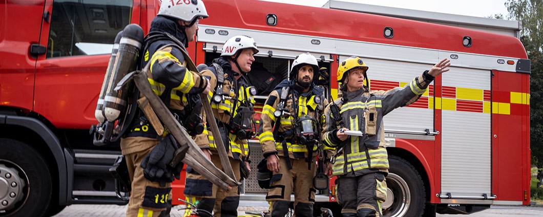 Firefighters team in front of fire engine