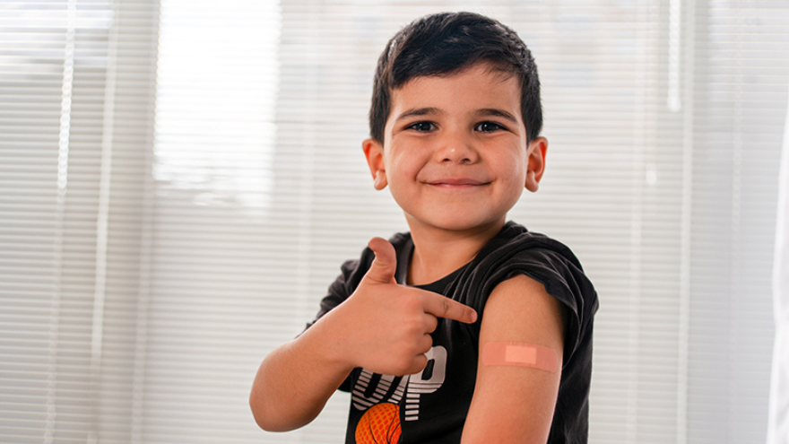 Kids pointing at vaccine location and smiling