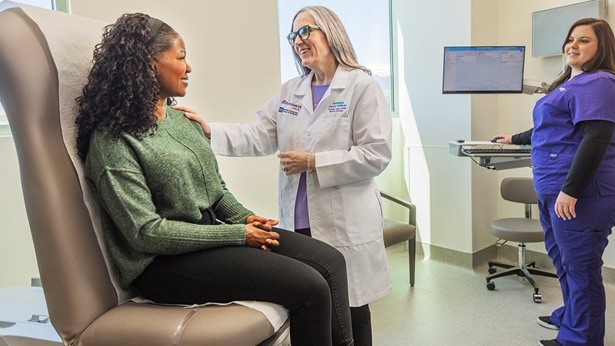 Renown provider speaks with patient as Renown nurse looks on