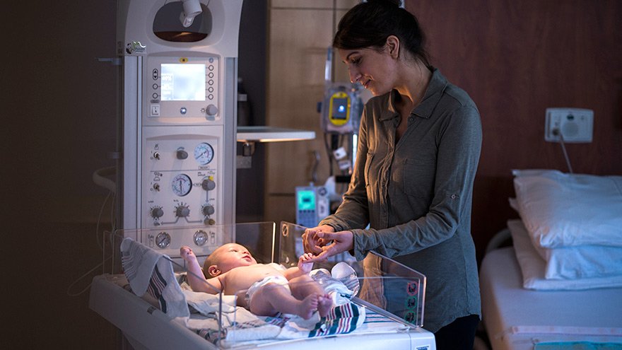 Mom holding baby's hand in Renown Health NICU