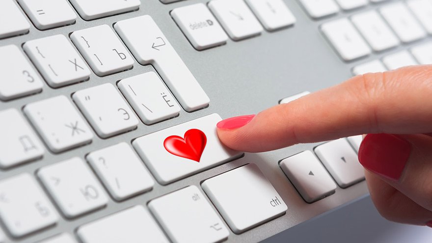 Woman's finger pressing a keyboard button with love-sign