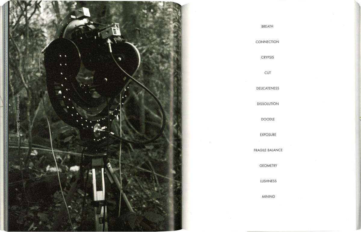 Scan of a book spread. On the left side a black and white image of a camera in the forest. On the right page a list of 12 words, set in capitals in black on a white background.