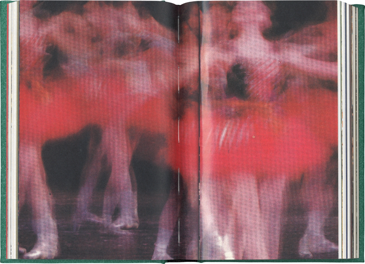 Scan of an interior spread of a book featuring a full bleed photo of blurry dancers wearing red tutus.