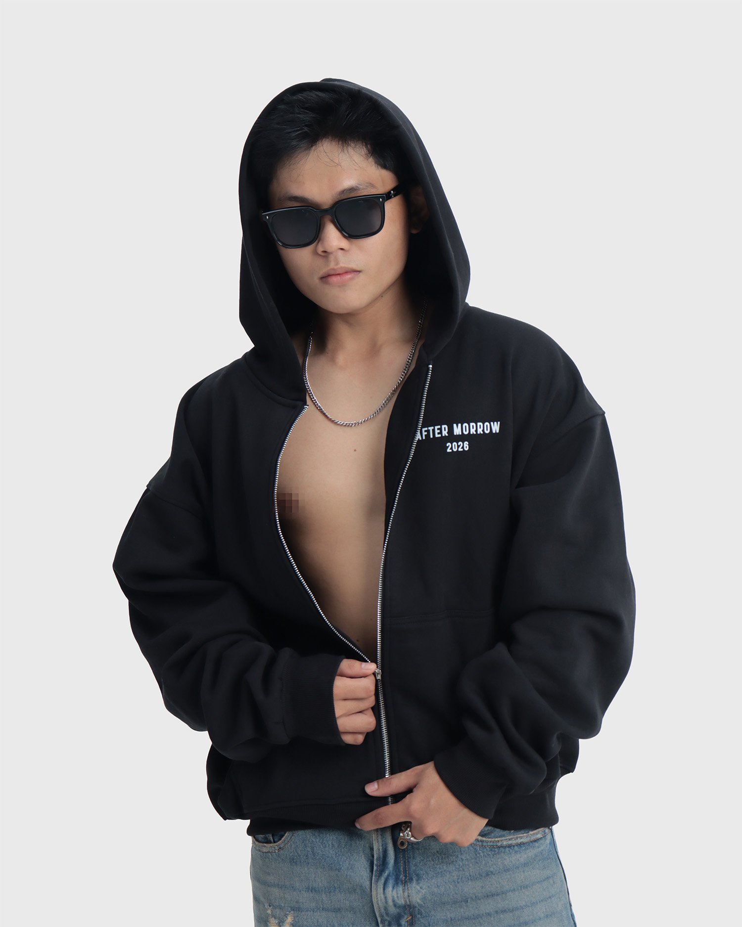 Model wearing the black AFTERMORROW heavyweight zip hoodie from the front