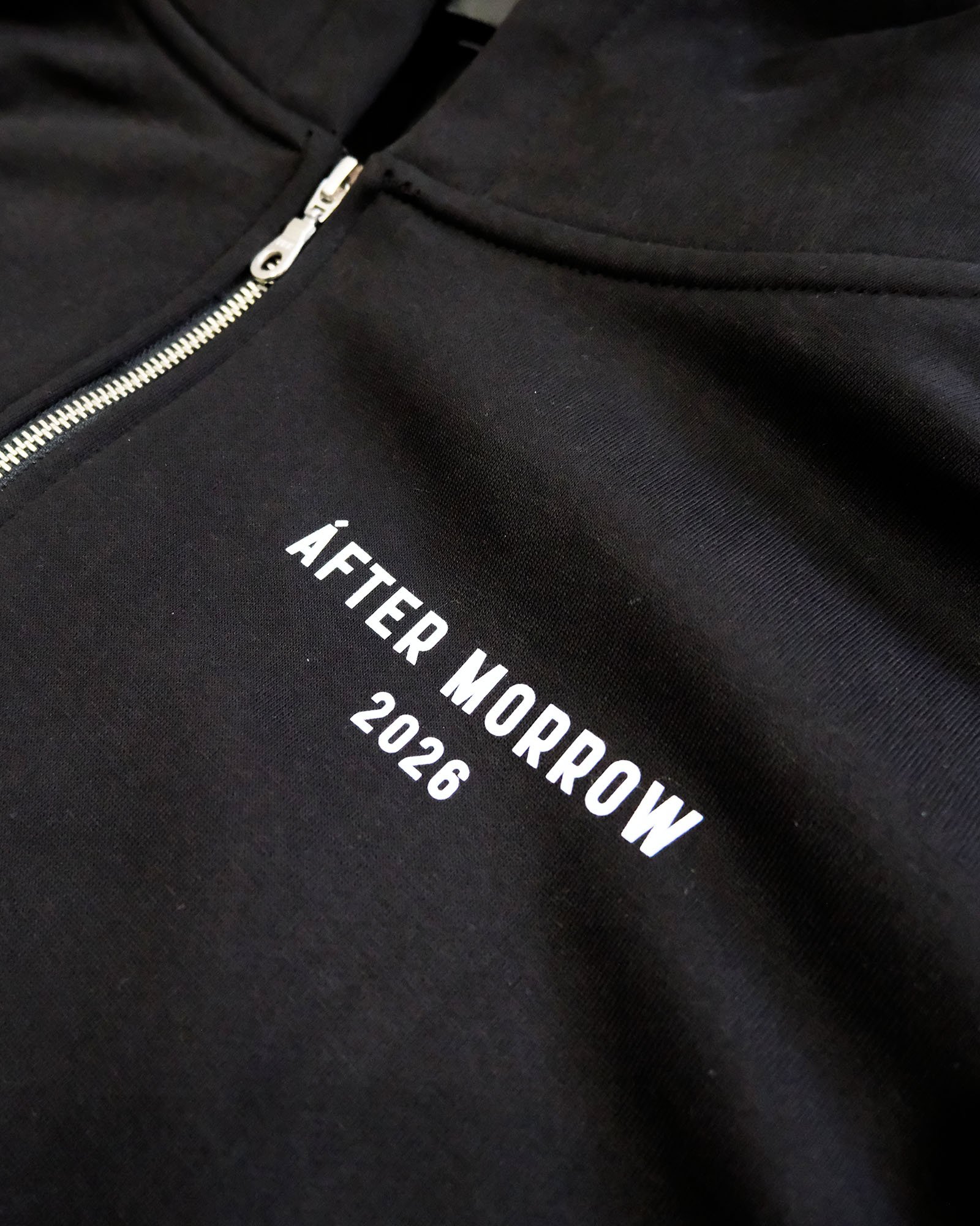 Model wearing the black AFTERMORROW heavyweight zip hoodie from the front