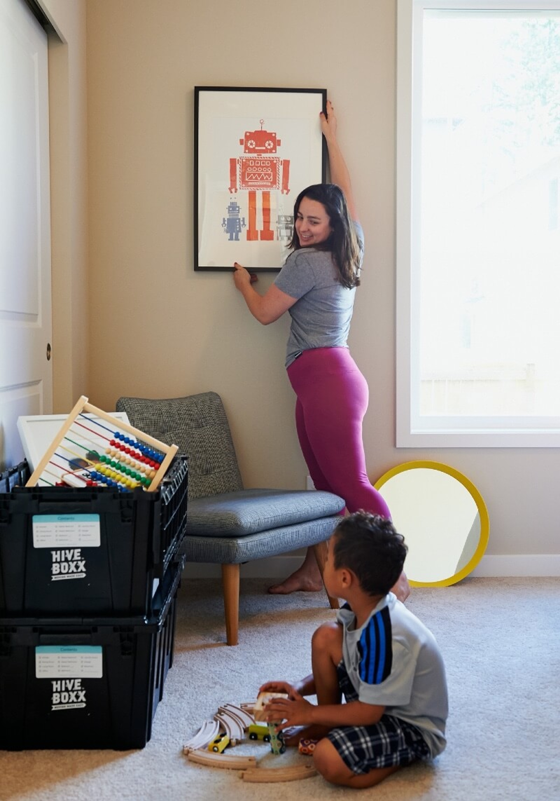 Woman packing belongings while her kid looks on