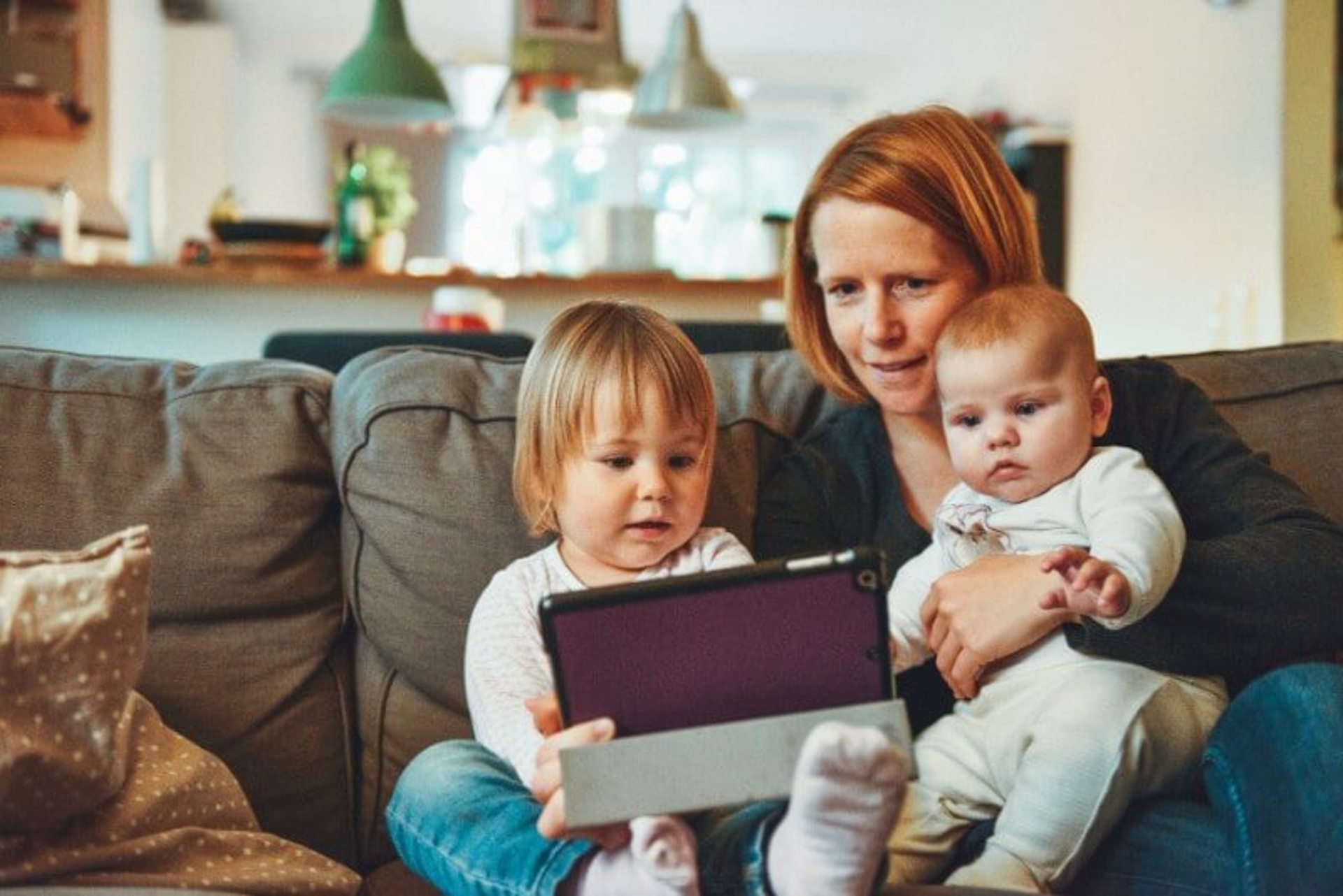 Mum with two kids on sofa with iPad