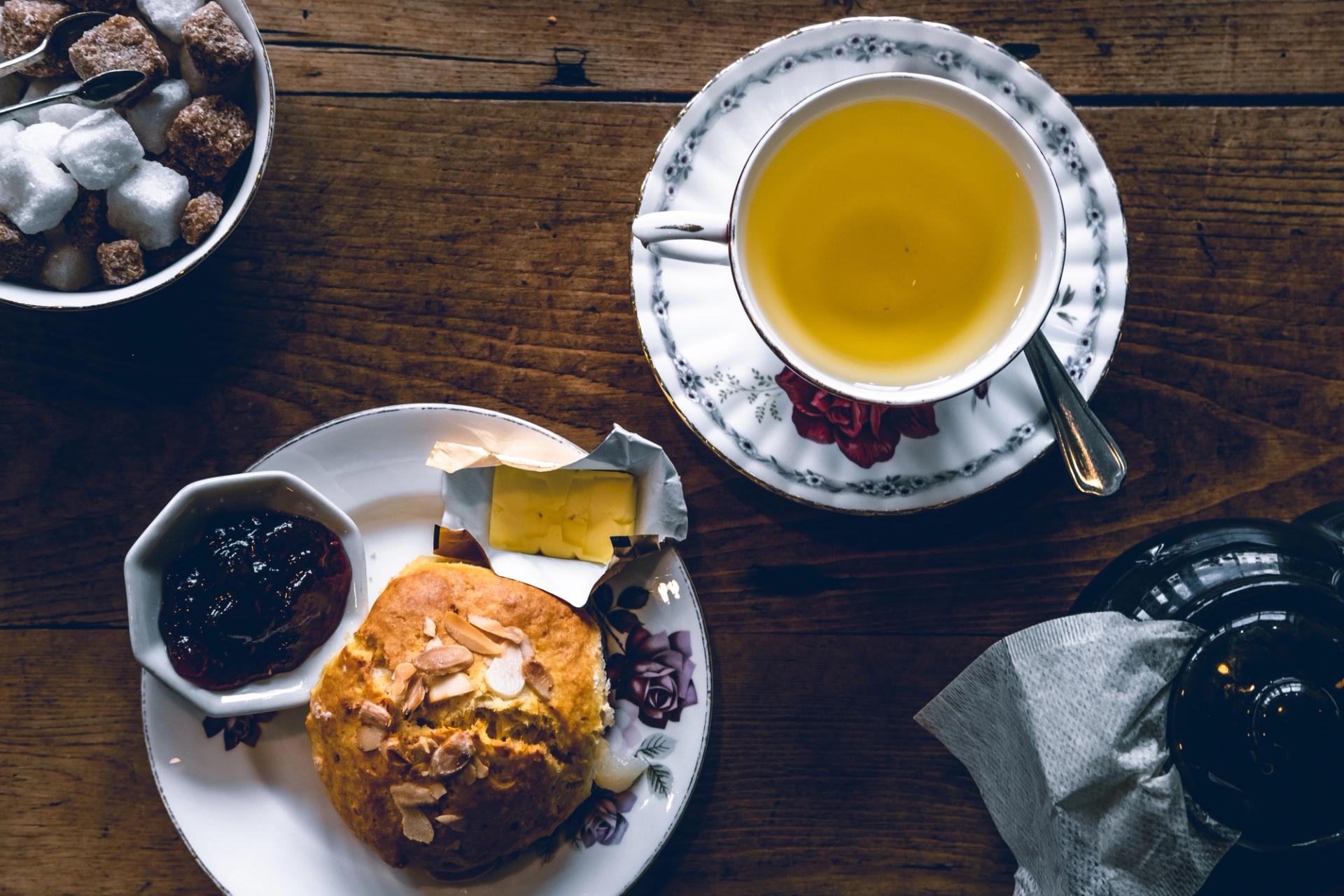 A cup of tea in a floral-patterned teacup with a saucer
