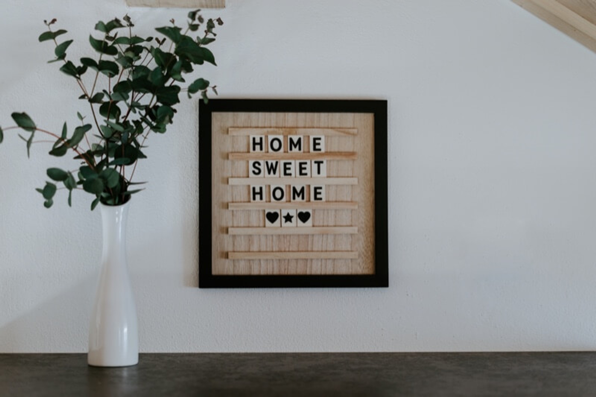 "home sweet home" written on a picture next to a flower pot