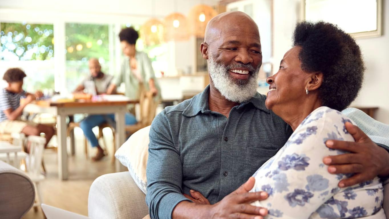 Couple smiling together at home, confident in their bright smiles
