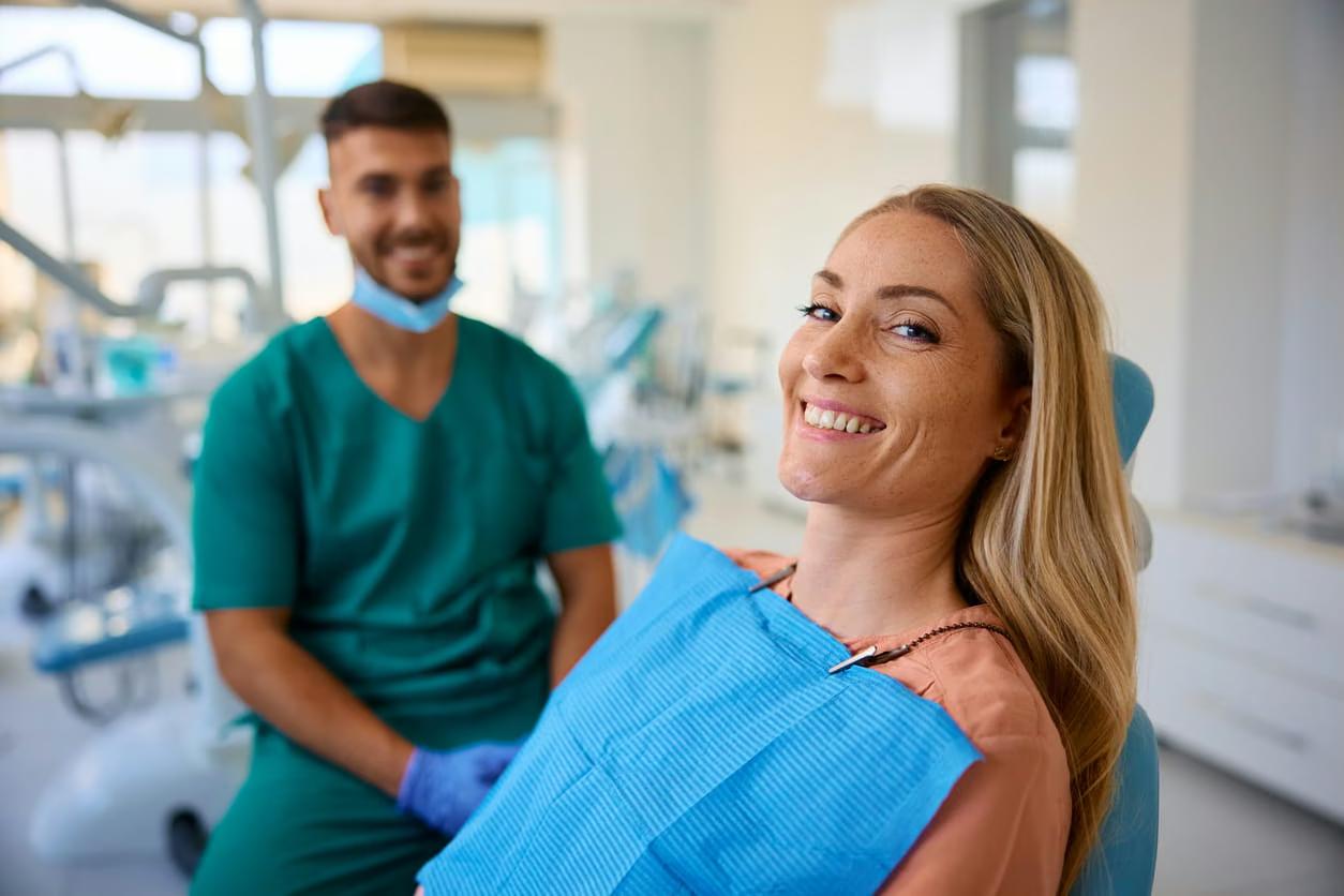 Dentist using a bleach-enhancing light during an in-office teeth whitening session