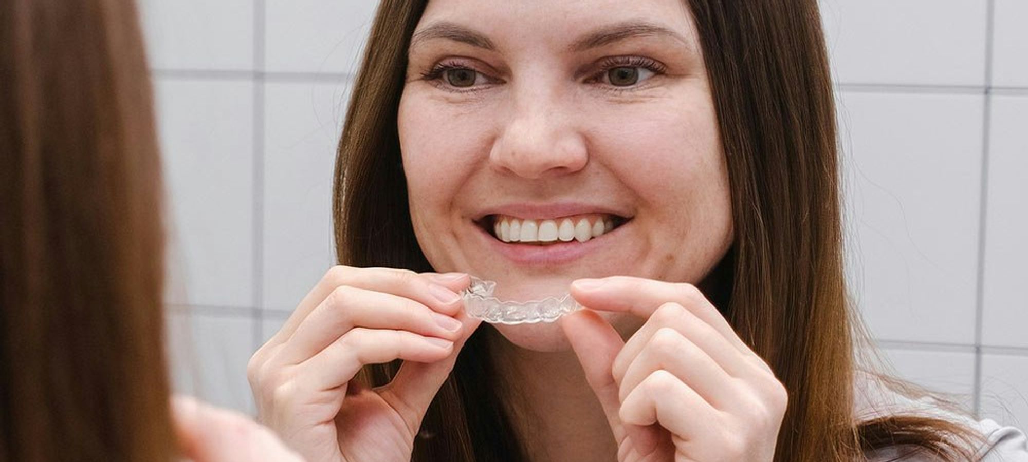 Woman putting on Invisalign