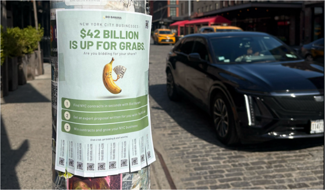 A Bid Banana flyer taped to a Manhattan lamppost reading “New York City businesses: $42 billion is up for grabs,” with a cartoon banana holding cash and tear-off QR code tabs.