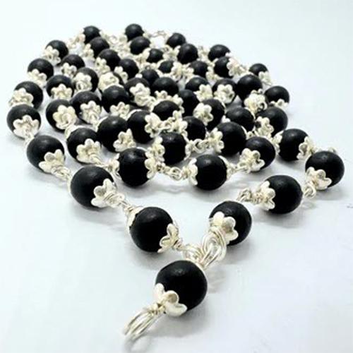 Long draped chain of matte black beads with silver-toned flower-shaped caps linked by silver-toned wire on a white background