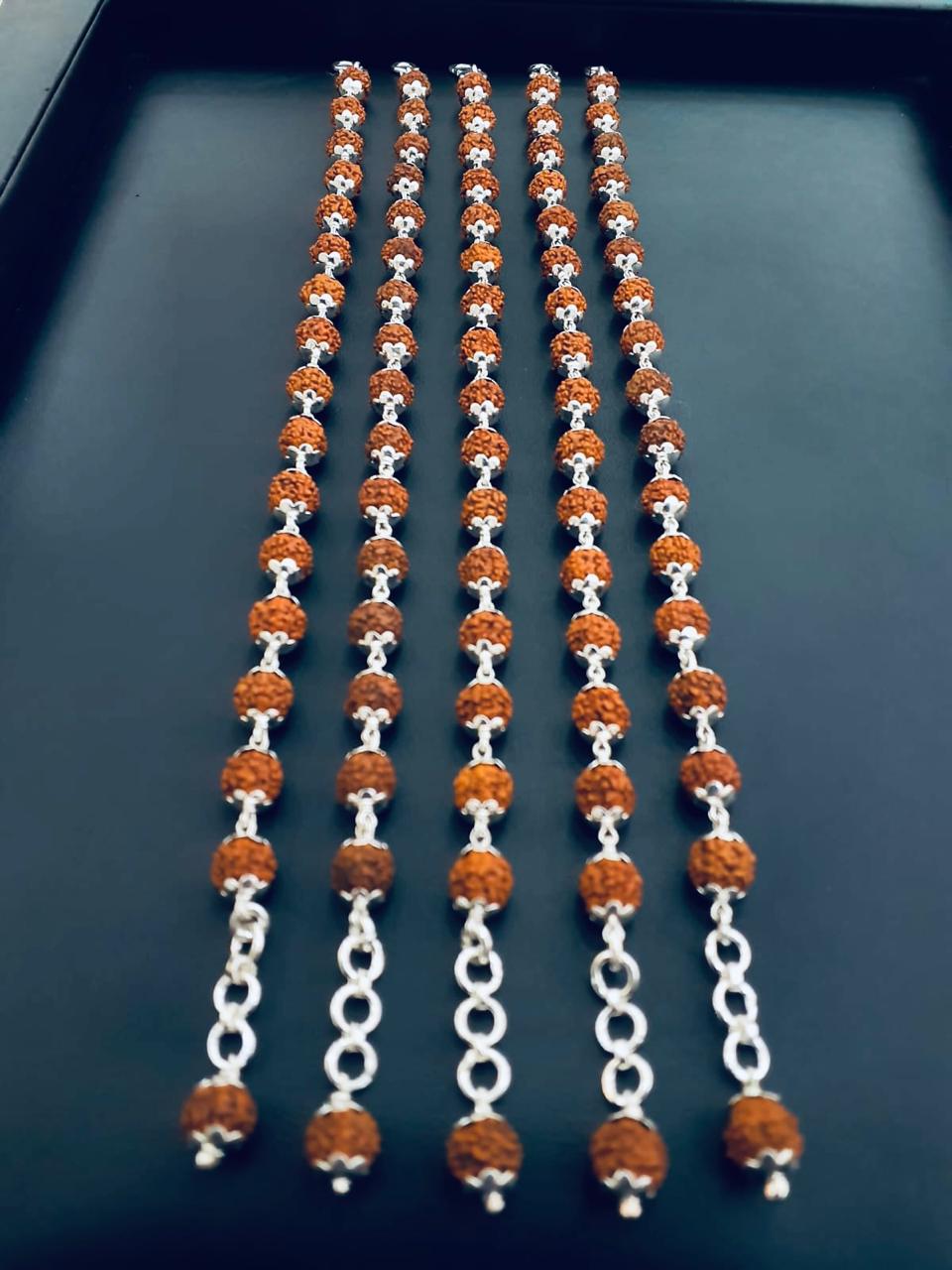 Five vertical strands of textured Rudraksha beads with silver-toned floral caps ending in ring links and a terminal capped bead