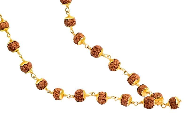 Long chain of textured Rudraksha beads with decorative yellow-gold toned petal caps and metal links on a white background