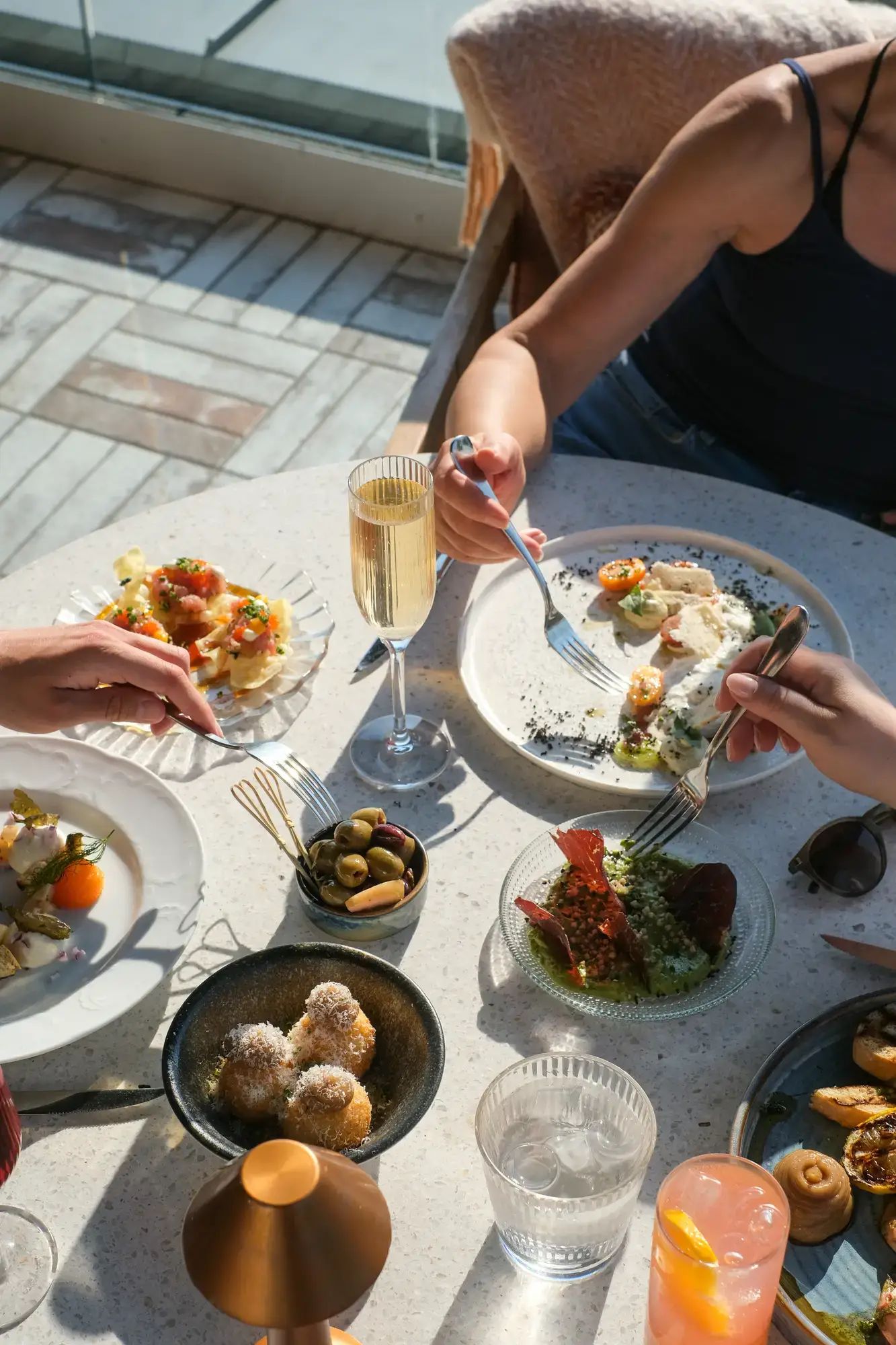 Personer delar mat vid bord med Stripe champagneglas och Stripe rocks glas på Rooftop by Vana i Karlstad.