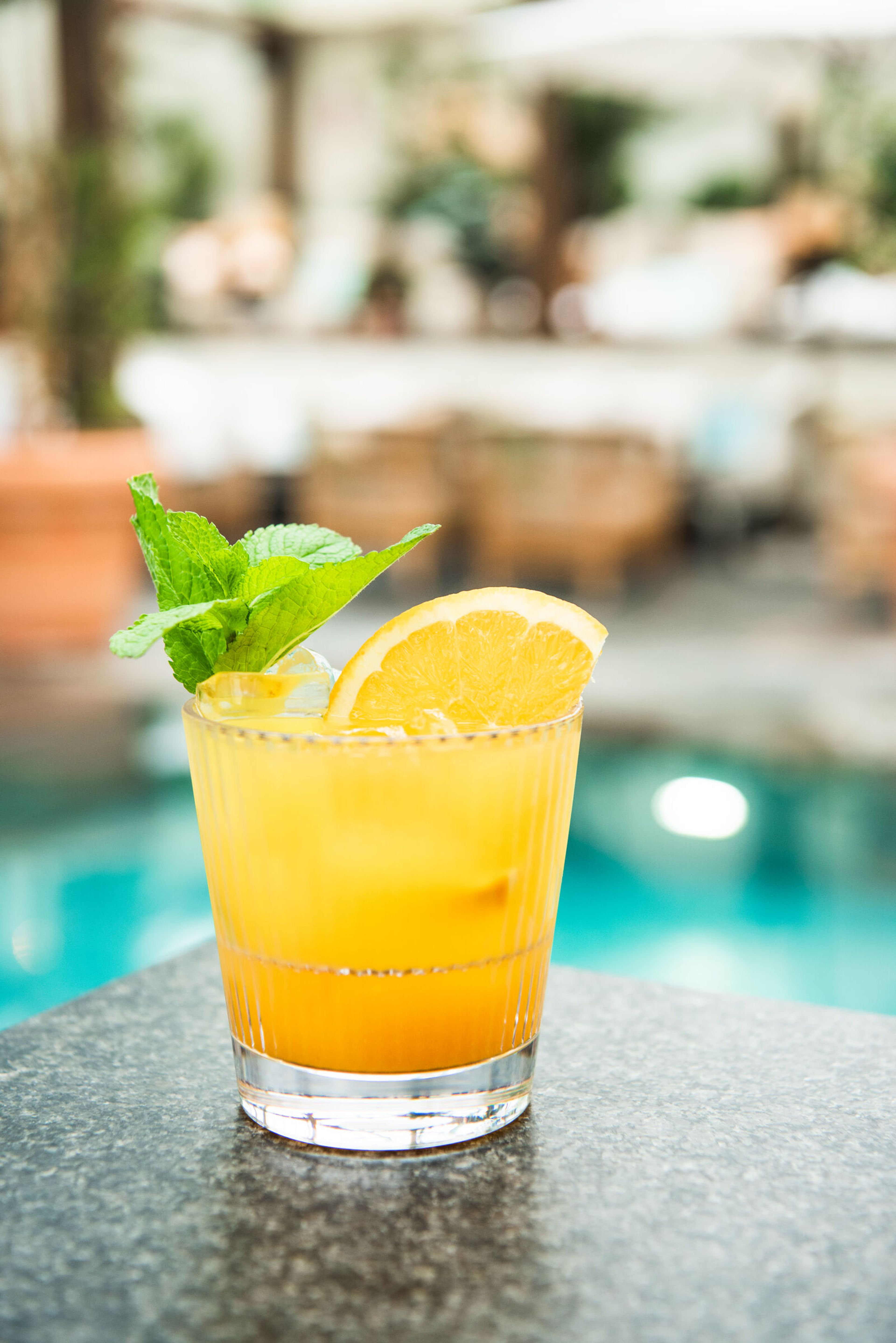 Orange cocktail i ett räfflat rocks-glas med citrusskiva.