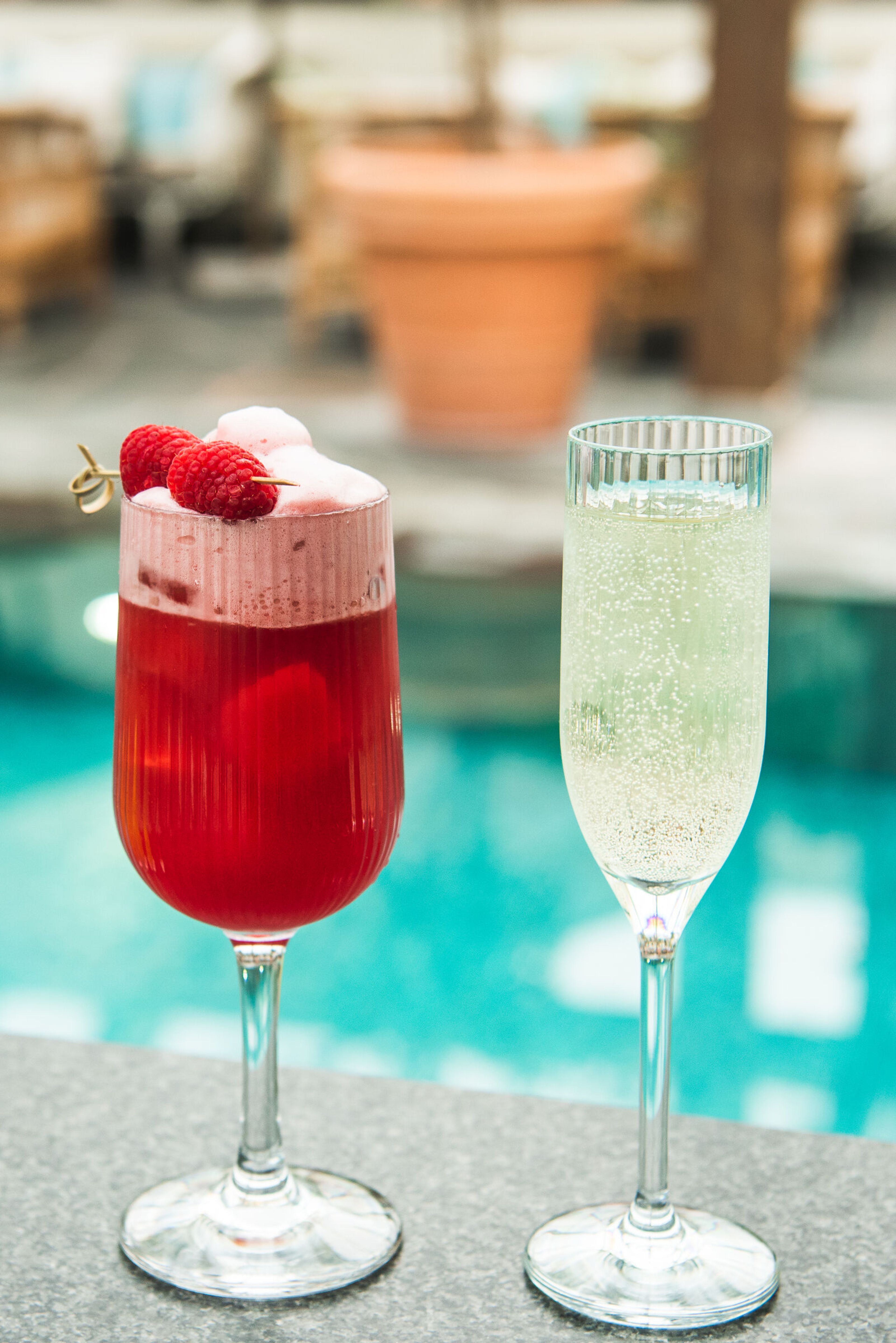 Halloncocktail med skum i ett vinglas bredvid en champagneflöjt.