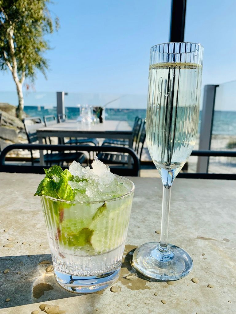Myntamojito i ett rocks-glas med krossad is bredvid en champagneflöjt.