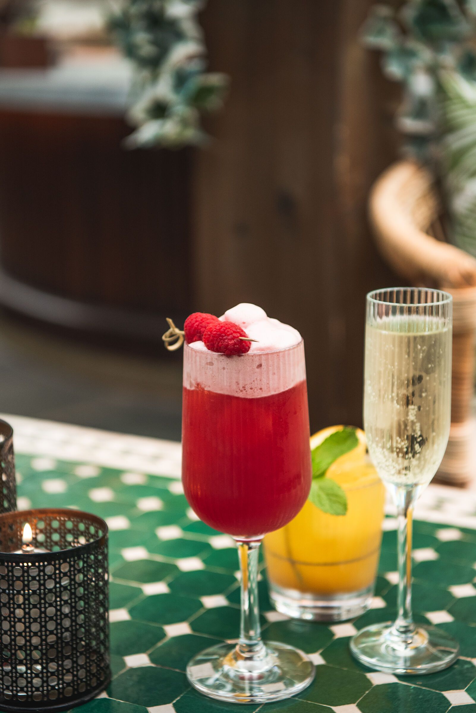 Tre cocktails på ett bord: hallon, mango och champagne.