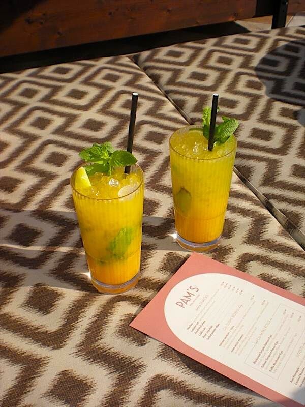 Två mangococktails i highballglas med myntagarnering.