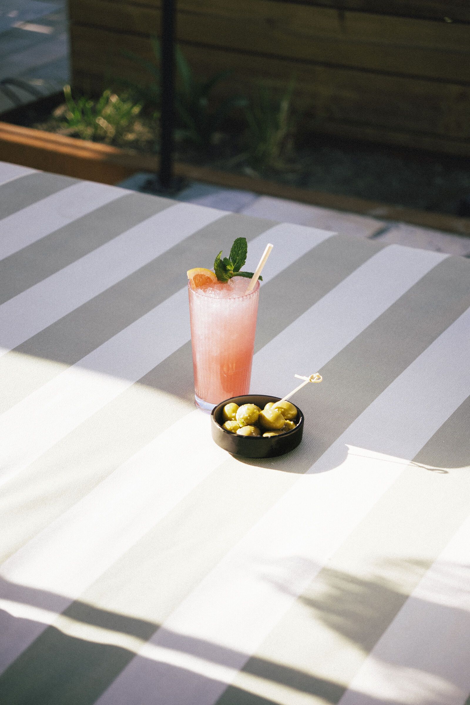 Rosa grapefruktcocktail i ett highballglas med myntagarnering.