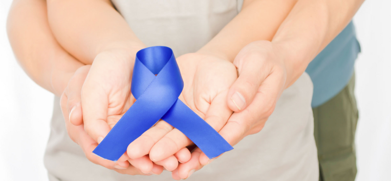 two pairs of hand holding a blue ribbon together 